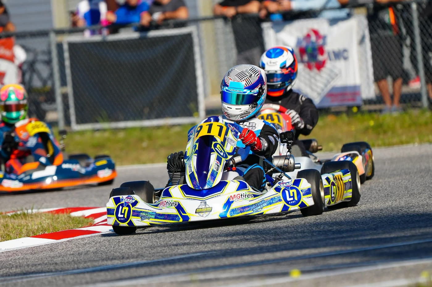 Kart at speed leading a group through a corner